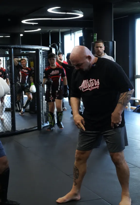 Headcoach Serdar Karaca vor der Trainingsgruppe am Käfig